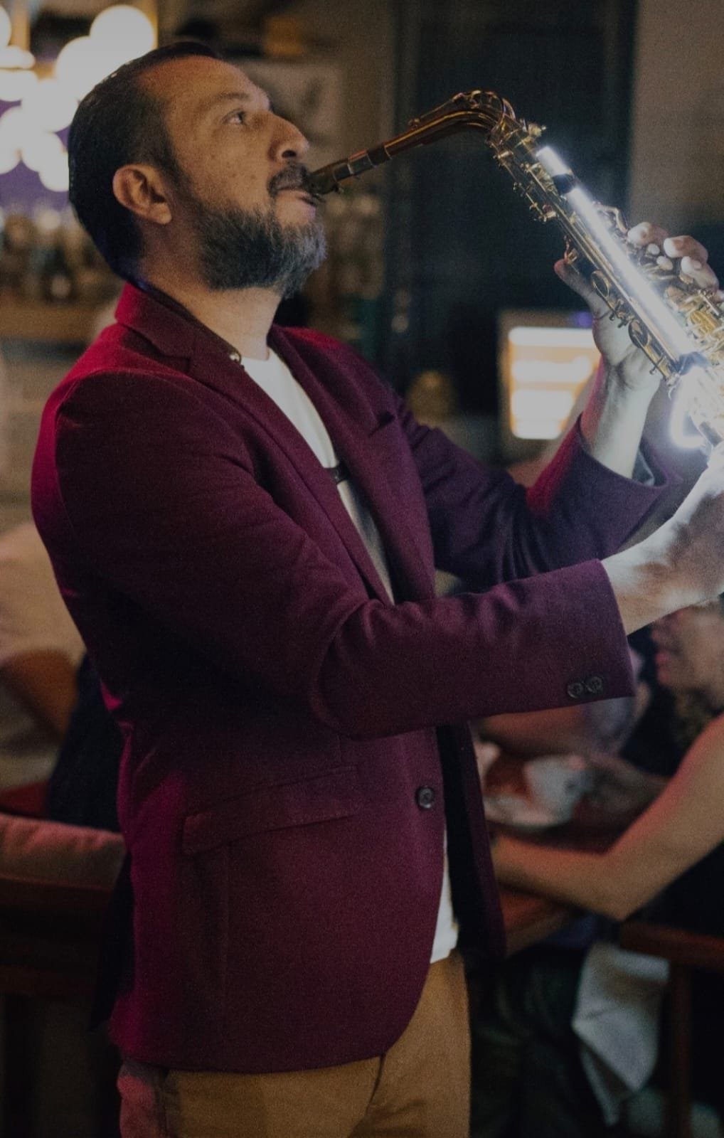 Fernando Carreto tocando saxofón en evento nocturno