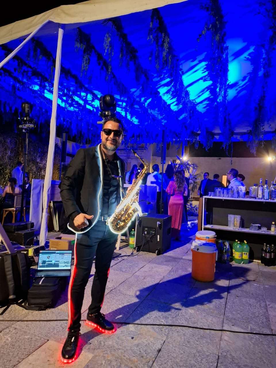 Fernando Carreto tocando saxofón iluminado en evento